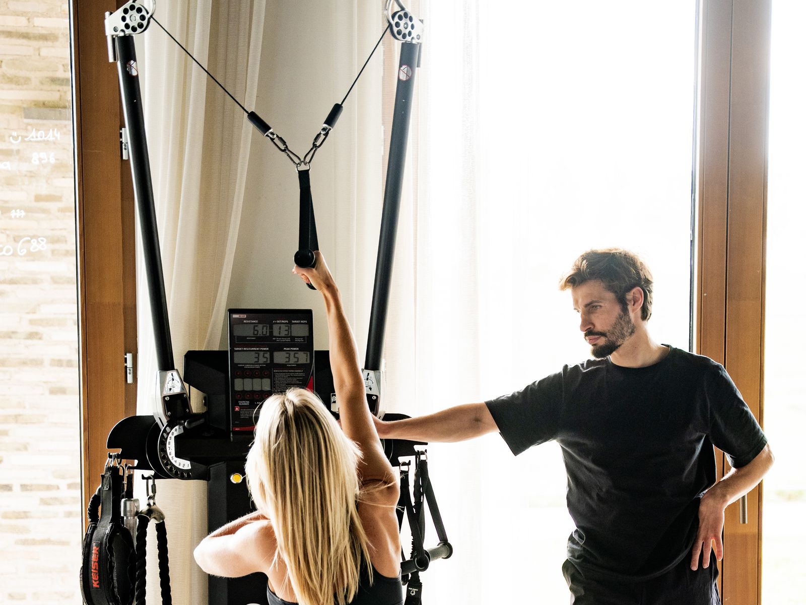 Coached session on a Keiser pneumatic cable machine